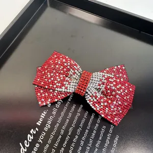 Gros plan de la barrette nœud rouge ornée de strass bicolores brillants et festifs