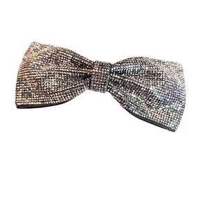 Vue détaillée de la barrette à nœud avec strass étincelants et texture en tissu gris argent