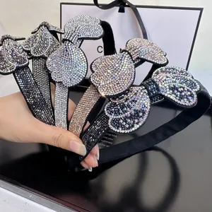 Close-up of sparkling rhinestone bow headbands in black, silver, and gold colors