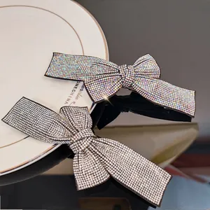 Detailed close-up of sparkling rhinestone bow hair clips on a luxury display base