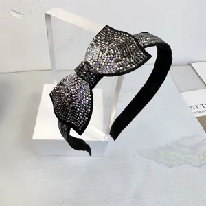 Détail du serre-tête nœud de luxe avec strass scintillants sur tissu noir élégant