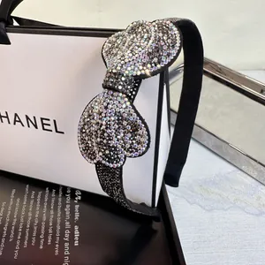 Macro detail of luxurious black headband featuring crystal-encrusted heart design on fabric