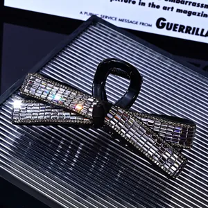 Macro shot of large black bow hair claw clip with shimmering rhinestones on glass tray