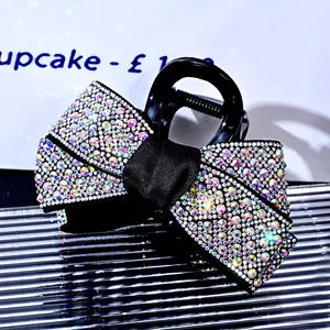 Macro view of rhinestone encrusted bow hair claw clip with colorful aurora crystal detail