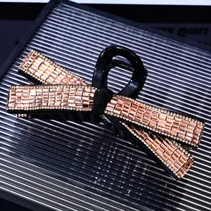 Detailed close-up of large bow hair claw clip with sparkling champagne rhinestones