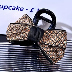 Macro shot of elegant bow hair claw clip with champagne rhinestones and silk center detail