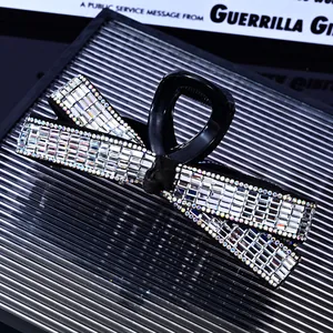 Detail of a large bow hair claw clip with rhinestones on a textured glass surface