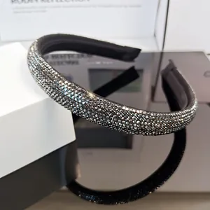 Detalle de diadema de lujo con pedrería y engaste denso sobre tela oscura