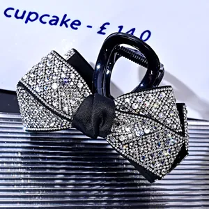 Close-up of sparkling rhinestones on a black bow-shaped hair claw clip accessory