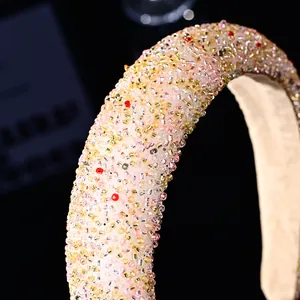 Macro detail of high-top padded headband with pink and gold luxury handmade beadwork