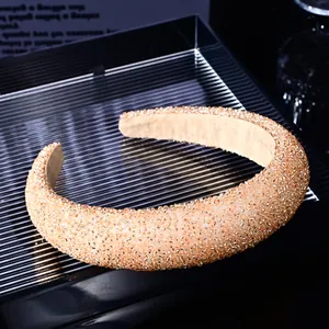 Macro view of champagne gold hand-beaded headband with thick sponge padding and texture
