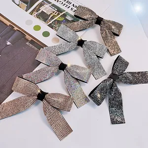 Barrette à cheveux avec nœud en strass brillants en champagne et argent sur fond de magazine