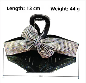 Detail view of a 13cm sparkling rhinestone bow hair claw clip showing size and weight