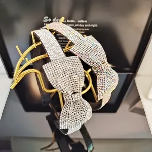 Close-up of sparkling rhinestone bow headbands in silver and iridescent colors on a stand