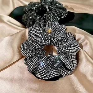 Detail shot of sparkling rhinestone scrunchies on premium silk background cloth