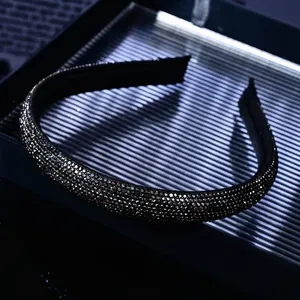 Close-up of black micro-paved rhinestones on a slim headband with sparkling luxury texture