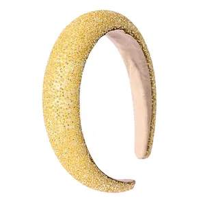Elegant high-crown headband with dense golden crystal beads on beige fabric lining