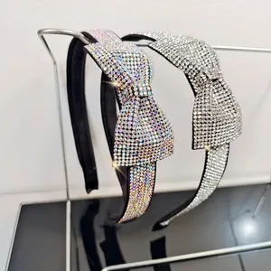 Detailed view of rhinestone bow headbands featuring sparkling crystals on metal display