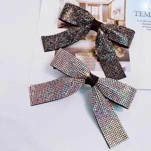 Détail de barrettes à nœuds élégantes avec strass brillants en noir et couleurs aurora