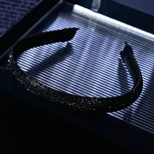Close-up of luxury thin black headband featuring dense shimmering rhinestones in detail