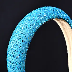 Primer plano macro de diadema azul con cristales rectangulares sobre fondo negro elegante