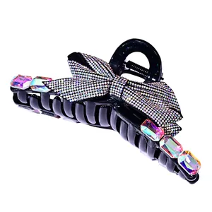 Black bow hair claw clip with rhinestones and aurora borealis crystals on white background