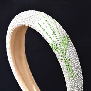 Vista macro de diadema acolchada con diamantes de imitación verdes y blancos fondo negro