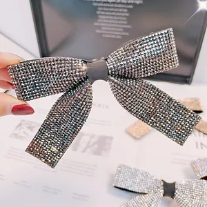 Gros plan d'une barrette à cheveux en forme de nœud ornée de strass gris foncé brillants