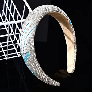 Primer plano de brillantes diamantes de imitación plateados y azules en una diadema ancha