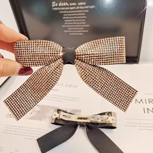 Détail d'une barrette à cheveux nœud avec strass dorés et pince à ressort de haute qualité