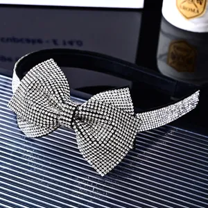 Close-up of a luxury bow headband with shimmering silver rhinestones on black fabric