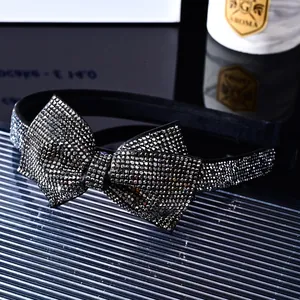 Macro shot of French vintage headband featuring a rhinestone bow on black fabric