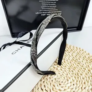 Serre-tête torsadé élégant avec strass étincelants sur un présentoir cadeau de luxe