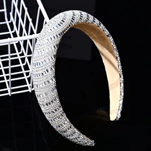 Detail of silver sponge headband with shimmering crystals on a black reflective background