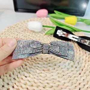 Barrette à cheveux avec nœud en strass colorés et fermoir à ressort en métal argenté