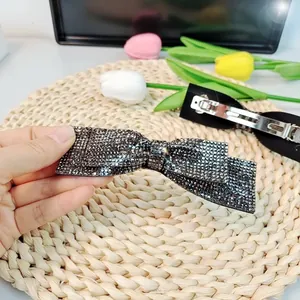 Détail de la pince à cheveux nœud avec strass gris foncé et fermoir à ressort argenté