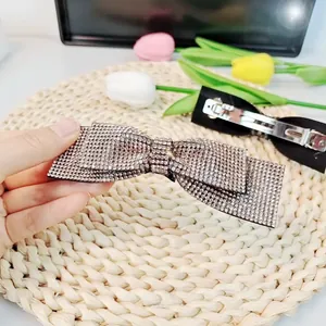 Détail d'une barrette à cheveux nœud en strass avec son fermoir à ressort métallique