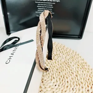 Détail d'un serre-tête élégant or champagne avec structure croisée et strass brillants
