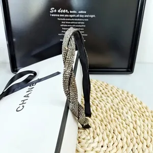 Vue détaillée du serre-tête avec strass argentés et design tressé torsadé