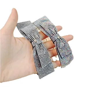 Détail de deux barrettes à cheveux en forme de nœud avec strass argentés et colorés