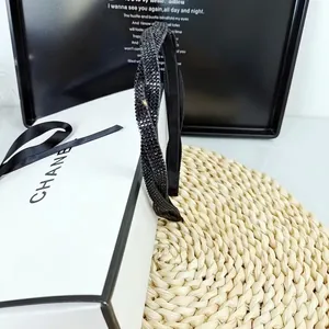 Vue détaillée d'un élégant serre-tête noir en strass avec un design torsadé chic