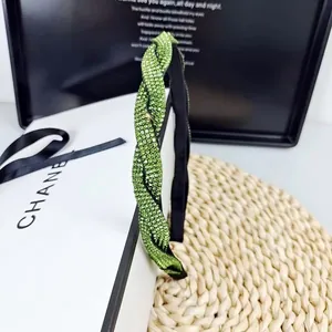 Gros plan détaillé du serre-tête vert orné de strass brillants avec un design tressé