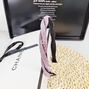 Détail d'un serre-tête élégant aux strass roses avec un design torsadé raffiné