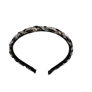 Diadema trenzada elegante con pedrería gris brillante sobre base de tela negra