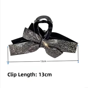 Macro detail of a 13cm black bow hair claw clip with shimmering rhinestones and 46g weight