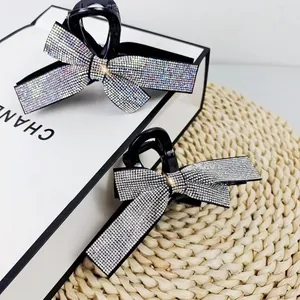 Elegant bow hair claw clips with shimmering rhinestones and black polished finish