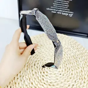 Serre-tête torsadé avec strass brillants sur fond texturé pour un style élégant