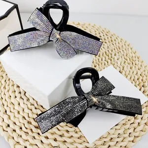 Detailed view of luxury bow hair claw clips with shimmering rhinestones in silver and black
