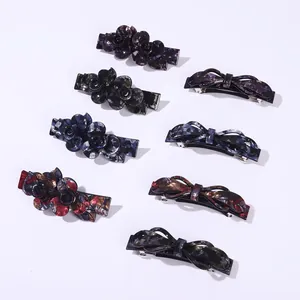 Acetate spring hair clips with floral and bow designs in various marble textures