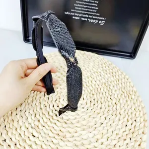 Détail du serre-tête à nœud en strass noirs montrant la texture étincelante des cristaux